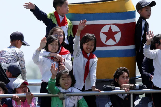 North Korean children wave during their tour on the Yalu River in Sinuiju, near the Chinese border city of Dandong, May 8, 2016. (Photo by Jacky Chen/Reuters)