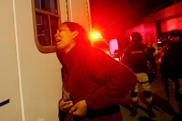 Viangly, a Venezuelan migrant, reacts outside an ambulance for her injured husband Eduard Caraballo while Mexican authorities and firefighters remove injured migrants, mostly Venezuelans, from inside the National Migration Institute (INM) building during a fire, in Ciudad Juarez, Mexico on March 27, 2023. (Photo by Jose Luis Gonzalez/Reuters)