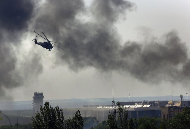 A Ukrainian helicopter Mi-24 gunship fires its cannons against rebels at the main terminal building of Donetsk international airport on May 26, 2014. Three Ukrainian helicopter gunships mounted a heavy attack on the rebel-held international airport terminal at Donetsk on Monday, firing rockets and cannon and throwing out decoy flares as militants shot at them from the ground. (Photo by Yannis Behrakis/Reuters)