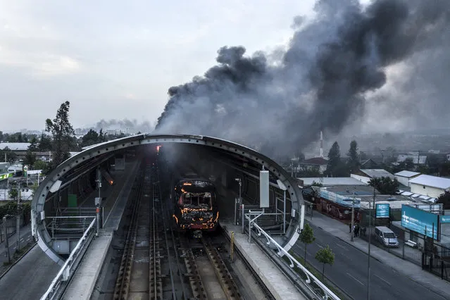 Aerial view of a burnt metro station after protests in Santiago on October 19, 2019. Chilean President Sebastian Pinera announced Saturday the suspension of the increase in the price of metro tickets which triggered violent protests. (Photo by Javier Torres/AFP Photo)