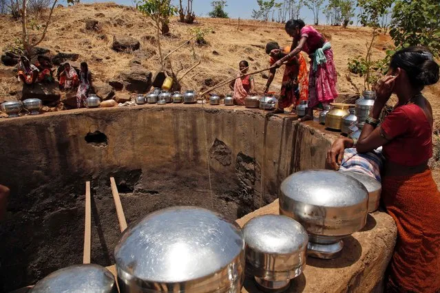 Women pulling a rope attached to a bucket as they draw drinking water from a well at Bhakrecha Pada in Thane district in Maharashtra state, India, Wednesday, May 4, 2016. Much of India is reeling under a weekslong heat wave and severe drought conditions that have decimated crops, killed livestock and left at least 330 million Indians without enough water for their daily needs. (Photo by Rajanish Kakade/AP Photo)
