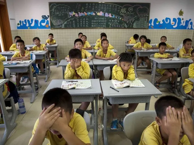 Young Chineseattend classes after training at the Evergrande International Football School near Qingyuan in Guangdong Province. (Photo by Kevin Frayer/Getty Images)