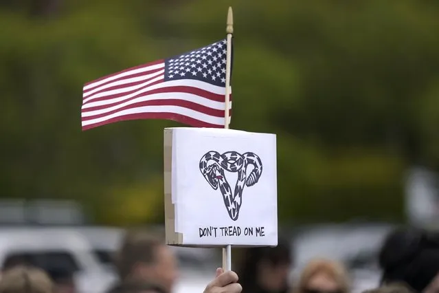 A person holds a sign that reads “Don't Tread On Me” with a uterus-shaped snake and an American  flag, Tuesday, May 3, 2022, during a rally at a park in Seattle in support of abortion rights. (Photo by Ted S. Warren/AP Photo)