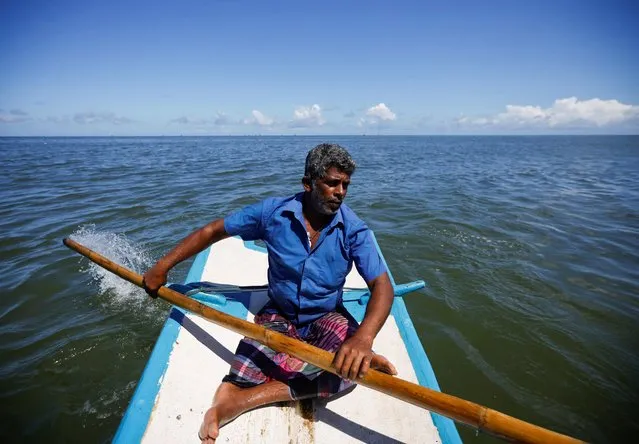 G.K Chaminda, 47, sails on his rowing boat along the Negombo beach, as fishermen and their families struggle due to a lack of diesel and a price hike over the last few months amid the country's economic crisis, in Negombo, Sri Lanka, April 16, 2022. (Photo by Navesh Chitrakar/Reuters)