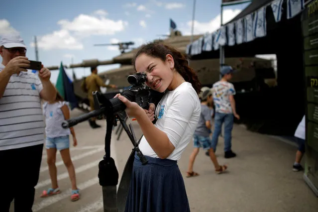 A girl plays with a rifle after a Memorial Day ceremony for the Fallen soldier at Latrun's armoured corps memorial site, Israel on May 8, 2019. (Photo by Corinna Kern/Reuters)