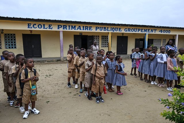 Pupils and teachers stand outside the classrooms at the primary school in Agre, Abidjan, on September 9, 2024 at beginning of the school year in Ivory Coast. (Photo by Issouf Sanogo/AFP Photo)