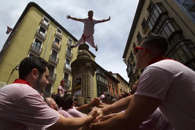 A reveller jumps from a fountain at Navarreria Street as people enjoy the atmosphere during the opening day or “Chupinazo” of the San Fermin Running of the Bulls fiesta on July 6, 2017 in Pamplona, Spain. (Photo by Pablo Blazquez Dominguez/Getty Images)