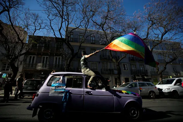 A participant carries a rainbow flag as they march during a Gay Pride Parade in downtown Lisbon, Portugal June 18, 2016. (Photo by Rafael Marchante/Reuters)