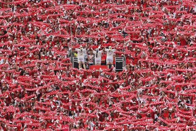 People wave the “Singapore” scarf during the National Day Parade at Padang on August 9, 2015 in Singapore. Singapore is celebrating her 50th year of independence on August 9, 2015. (Photo by Suhaimi Abdullah/Getty Images)