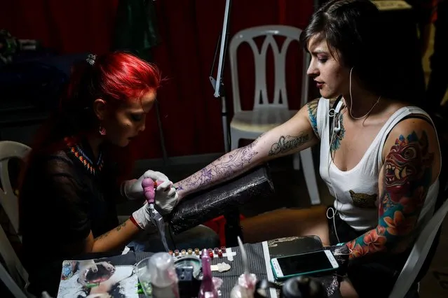 A woman works in a tattoo during the 8thExpotattoo Colombia Fair in Medellin, Antioquia department, on July 14, 2017. (Photo by Joaquin Sarmiento/AFP Photo)