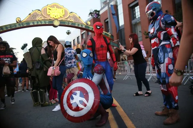 Cosplay characters dressed as Spiderman, pose for pictures along 5th Avenue in the Gaslamp Quarter during Comic Con International on July 20, 2017 in San Diego, California. Comic Con International is North America's largest Comic convention featuring  pop culture and entertainment elements across virtually all genres, including horror, animation, anime, manga, toys, collectible card games, video games, webcomics, and fantasy novels as well as movie premieres and actor panels. (Photo by Sandy Huffaker/Getty Images)