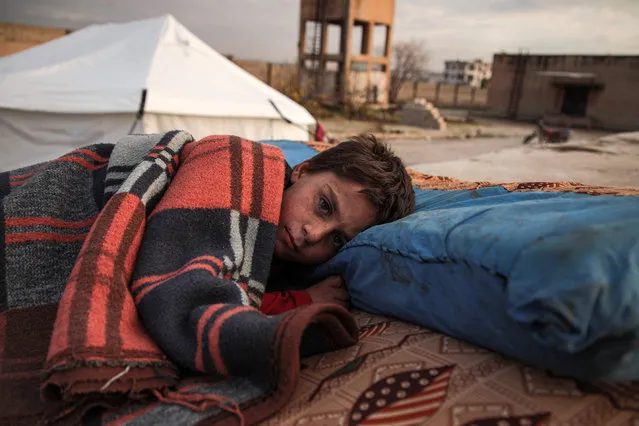 A Syrian child, one of those who fled from government forces' advance on Maaret al-Numan in the south of Idlib prvoince, sleeps on a futon in the open at a camp for the displaced near the town of Dana in the province's north near the border with Turkey, on December 27, 2019. (Photo by Aaref Watad/AFP Photo)