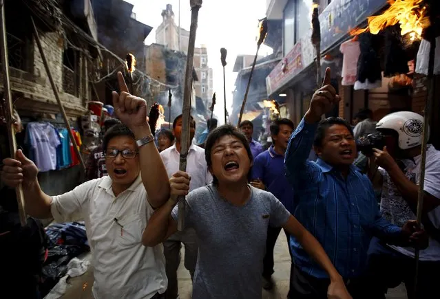Protesters chant slogans during a torch rally organised by the 30-party alliance led by a hardline faction of former Maoist rebels, who are protesting against the draft of the new constitution, in Kathmandu August 15, 2015. The group says that the draft is not inclusive and does not protect the rights of the marginalised and underprivileged groups in the country. (Photo by Navesh Chitrakar/Reuters)