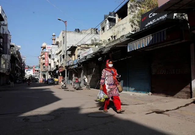 A woman walks along a near-empty street during a lockdown amid a coronavirus disease (COVID-19) outbreak in New Delhi, India, March 25, 2020. (Photo by Adnan Abidi/Reuters)