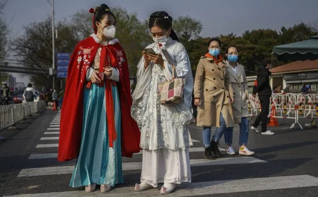 Chinese women wear protective masks as they are dressed in traditional clothing from the Qing Dynasty era outside a park on March 29, 2020 in Beijing, China. A limited section of the iconic tourist site was re-opened to the public this week allowing a smaller number of visitors to reserve tickets online in advance and to enter after passing health screening. With the pandemic hitting hard across the world, China recorded its first day with no new domestic cases of the coronavirus last week, since the government imposed sweeping measures to keep the disease from spreading. For two months, millions of people across China have been restricted in how they move from their homes, while other cities have been locked down in ways that appeared severe at the time but are now being replicated in other countries trying to contain the virus. Officials believe the worst appears to be over in China, though there are concerns of another wave of infections as the government attempts to reboot the worlds second largest economy. In Beijing, it is mandatory to wear masks outdoors, retail stores operate on reduced hours, restaurants employ social distancing among patrons, and tourist attractions at risk of drawing large crowds remain closed. Monitoring and enforcement of virus-related measures and the quarantine of anyone arriving to Beijing is carried out by neighborhood committees and a network of Communist Party volunteers who wear red arm bands. A primary concern for Chinese authorities remains the arrival of flights from Europe and elsewhere, given the exposure of passengers in regions now regarded as hotbeds for transmission. Since January, China has recorded more than 81,000 cases of COVID-19 and at least 3200 deaths, mostly in and around the city of Wuhan, in central Hubei province, where the outbreak first started. (Photo by Kevin Frayer/Getty Images)
