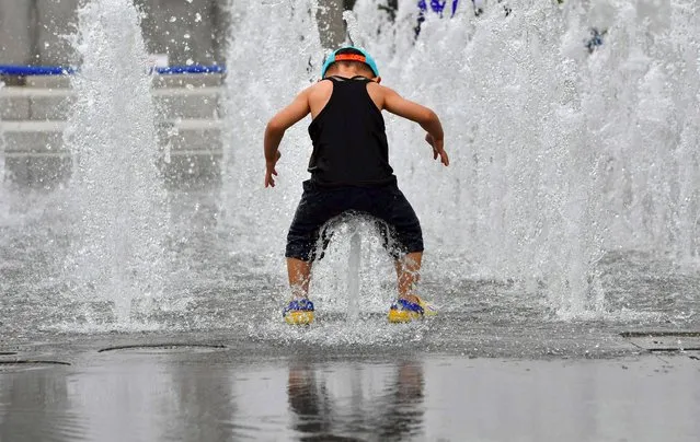 A boy plays in a fountain to beat the heat in central Seoul on July 22, 2016. (Photo by Jung Yeon-Je/AFP Photo)