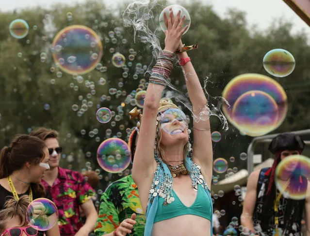 A festival goer bursts a soap bubble at Bestival, held at Robin Hill Adventure Park, Isle of Wight, England, Friday September 5, 2014. (Photo by Yui Mok/AP Photo/PA Wire)