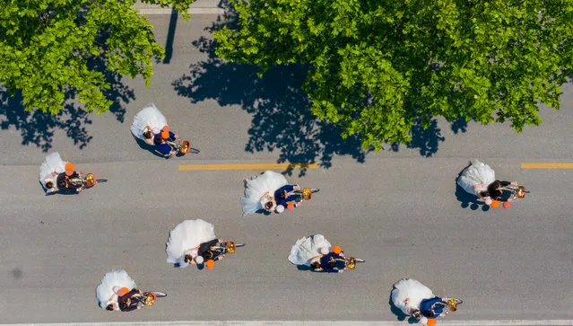 Ten couples ride bikes around the lake to celebrate their marriage. Haian City, Jiangsu Province, China, April 29, 2020. (Photo by Costfoto/Barcroft Media via Getty Images)