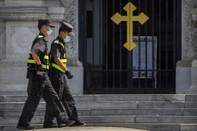 Security officers on patrol walk past the gates of the Wangfujing Church, a Catholic church in Beijing, Wednesday, September 14, 2022. Chinese President Xi Jinping's first trip overseas since the early days of the COVID-19 pandemic will overlap with a visit by Pope Francis to Kazakhstan, although the Vatican says there are no plans for them to meet. (Photo by Mark Schiefelbein/AP Photo)