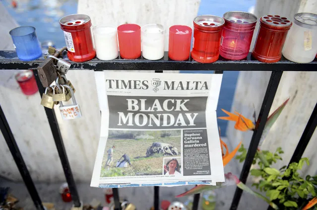 Candles, notes and paper cuttings lie next to the Love Monument in St. Julian, Malta, Tuesday October 17, 2017 the day after the killing of journalist Daphne Caruana Galizia. Daphne Caruana Galizia, the Maltese investigative journalist who exposed the island nation's links to offshore tax havens through the leaked Panama Papers, was killed Monday when a bomb exploded in her car. (Photo by Rene Rossignaud/AP Photo)