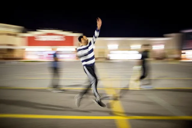 Asif Altaf bowls as a group of friends who have attended Sir Syed University in Pakistan play a game of cricket in a shopping mall parking lot, the only space available with lights at midnight, when they can leave their homes after work and family duties, in Mississauga, Ontario, Canada on September 3, 2022. (Photo by Carlos Osorio/Reuters)