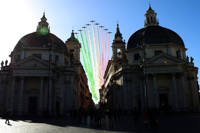 Planes of the Italian Air Force aerobatic unit Frecce Tricolori (Tricolor Arrows) spread smoke with the colors of the Italian flag as they fly over Piazza de Popolo in Rome on November 4, 2023 as part of celebrations of National Unity and Armed Forces Day, marking the end of the World War I in Italy. (Photo by Alberto Pizzoli/AFP Photo)