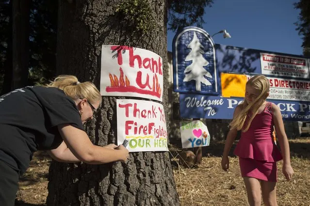 Angela Warden displays a “thank you” sign for firefighters battling the King Fire in Pollock Pines, California September 17, 2014. (Photo by Noah Berger/Reuters)