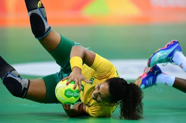 Brazil's centre back Ana Paula Belo falls with the ball during the women's preliminaries Group A handball match Brazil vs Spain for the Rio 2016 Olympics Games at the Future Arena in Rio on August 10, 2016. (Photo by Franck Fife/AFP Photo)