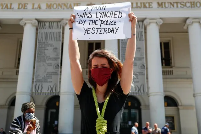 A protester wearing a face mask, holds a placard as she takes part in a protest against the death in Minneapolis police custody of African-American man George Floyd, in central Brussels, Belgium on June 1, 2020. (Photo by Francois Lenoir/Reuters)