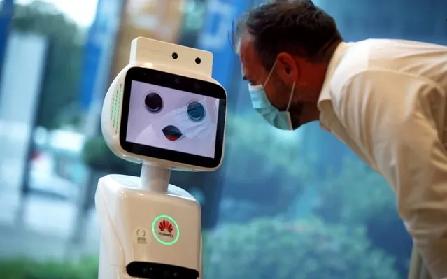A 5G-robot, that is able to measure the temperature of a person and controls wether a face mask is being worn, speaks to an employee, following the coronavirus disease (COVID-19) outbreak in Linz, Austria, June 9, 2020. (Photo by Lisi Niesner/Reuters)