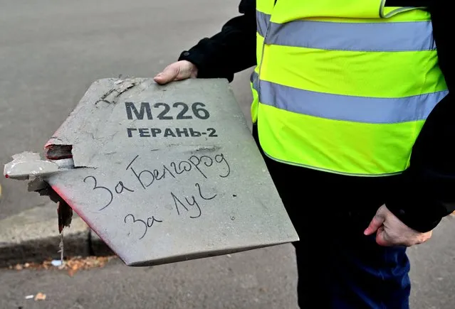 A police expert holds a fragment of a drone with a handwritten inscription reading “For Belgorod. For Luch” after a drone attack in Kyiv on October 17, 2022, amid the Russian invasion of Ukraine. (Photo by Sergei Supinsky/AFP Photo)
