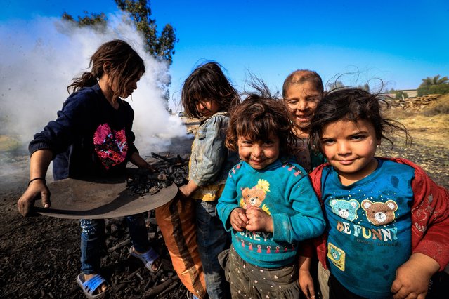 Iraqi children living in hard conditions help their family turn the wood they collect into charcoal and sell it in the market, making their living, in Yusufiya district of Baghdad, Iraq on February 17, 2025. Charcoal producers, who face struggles in the profession they inherited from their ancestors, travel around Baghdad and its surroundings to collect tree branches, and if they cannot find them, they buy wood to produce charcoal. (Photo by Murtadha Al-Sudani/Anadolu via Getty Images)