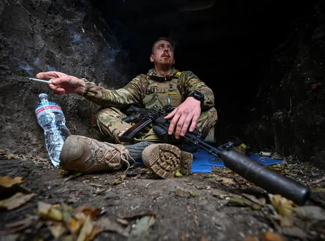 A serviceman rests in a trench at his position on a front line in Zaporizhzhia region, Ukraine on November 3, 2022. (Photo by Reuters/Stringer)