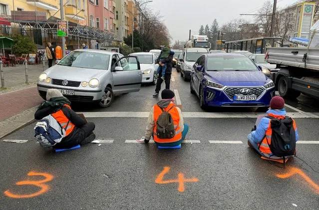 Climate-change activists of  “Letzte Generation” (Last Generation) sit glued to a road to block traffic during morning rush hour in Berlin, Germany on November 21, 2022. (Photo by Nicole Moritz/Reuters)
