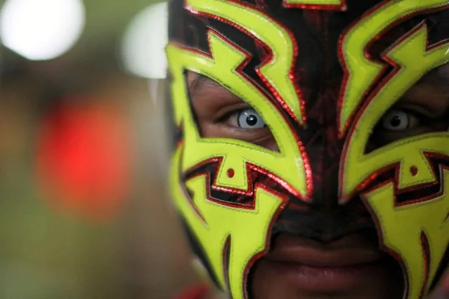 A Mexican wrestler poses for a picture before entering the ring to participate in a “Lucha Libre” (wrestling bout) at the Central de Abastos wholesale market in Mexico City, Mexico on November 11, 2022. (Photo by Raquel Cunha/Reuters)