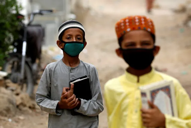 Boys wear protective masks as they head to the madrasa (religious school), during an anti-polio campaign, in a low-income neighborhood as the spread of the coronavirus disease (COVID-19) continues, in Karachi, Pakistan on July 20, 2020. (Photo by Akhtar Soomro/Reuters)