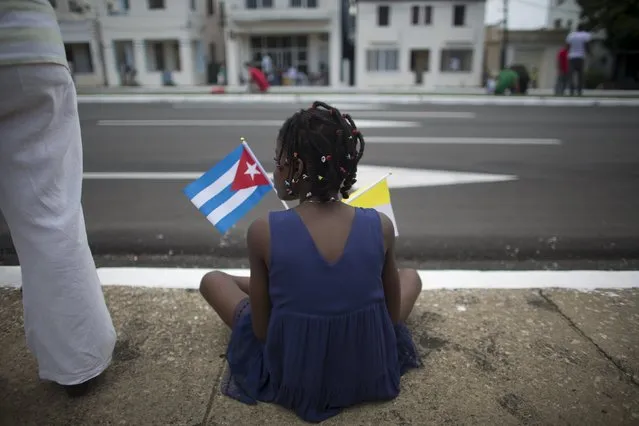 A child holds a Cuban and a Vatican flag as she waits for the arrival of Pope Francis from the airport in Havana, September 19, 2015. (Photo by Alexandre Meneghini/Reuters)