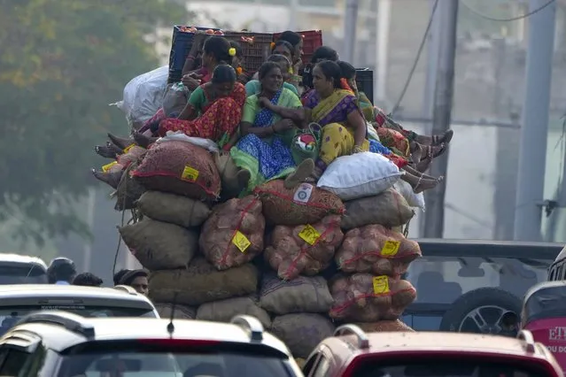 Vendors sit atop a mini truck with sacks of vegetables and travel to a market in Hyderabad, India, Thursday, December 22, 2022. (Photo by Mahesh Kumar A./AP Photo)