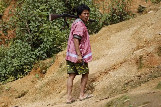 An ethnic Kayaw man walks with a gun at Htaykho village in the Kayah state, Myanmar September 13, 2015. (Photo by Soe Zeya Tun/Reuters)
