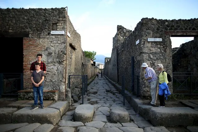 Tourists look down an ancient Roman cobbled street at the UNESCO World Heritage site of Pompeii, October 13, 2015. (Photo by Alessandro Bianchi/Reuters)