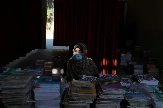 A Palestinian teacher wears a protective face mask as she waits to hand out books to students at a school as part of preparations by the ministry of education to reopen schools amid the coronavirus disease (COVID-19) outbreak, in the northern Gaza Strip on October 6, 2020. (Photo by Mohammed Salem/Reuters)