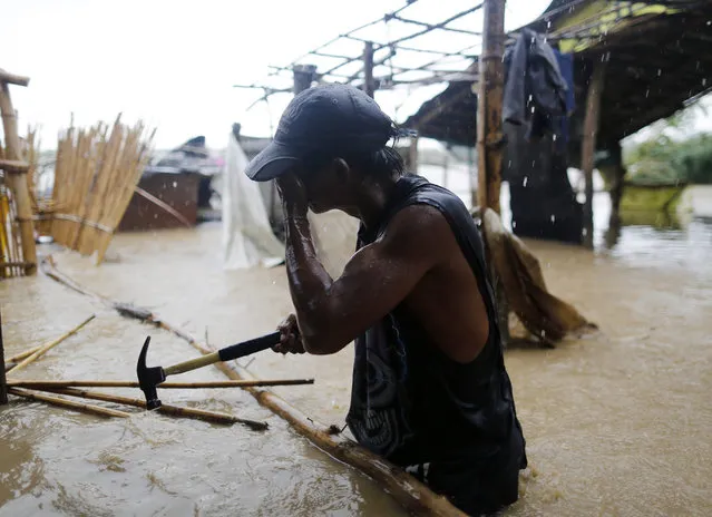 A Filipino villager reacts as he collects house materials damaged by flood brought about by Typhoon Sarika in the town of San Leonardo, Nueva Ecija province, Philippines, 16 October 2016. According to media reports typhoon Sarika has left two dead and thousands have been evacuated as it hit northeast of the Philippines. Several air carriers have cancelled flights to the country, as the Philippine Atmospheric Geophysical and Astronomical Services Administration (PAGASA) expects another storm, Haima, to make landfall on 17 October. (Photo by Francis R. Malasig/EPA)
