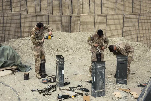 U.S. soldiers from the 3rd Cavalry Regiment unpack ordinance to replace mortar rounds fired during an exercise on forward operating base Gamberi in the Laghman province of Afghanistan December 24, 2014. (Photo by Lucas Jackson/Reuters)