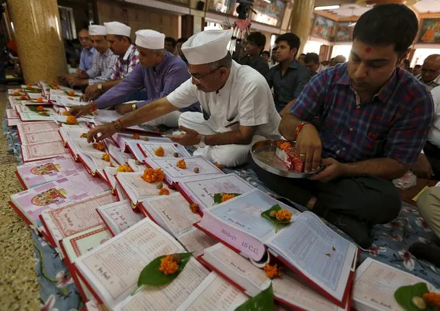 Indian businessmen prepare their record-keeping books as part of a ritual to worship the Hindu deity of wealth goddess Lakshmi on Diwali, the Indian festival of lights, in Ahmedabad, India, November 11, 2015. (Photo by Amit Dave/Reuters)