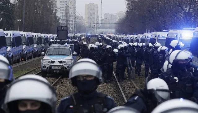 Police in riot gear block the path of anti-government protesters trying to reach the home of the ruling party leader, Jaroslaw Kaczynski, in Warsaw, Poland, Sunday December 13, 2020. Thousands of anti-government protesters demonstrated in Warsaw in the latest large protest after a high court ruled in October to further tighten the country's already restrictive abortion law. Sunday's protest was scheduled to coincide with the 39th anniversary of the 1981 martial law crackdown by the country's communist regime. (Photo by Czarek Sokolowski/AP Photo)