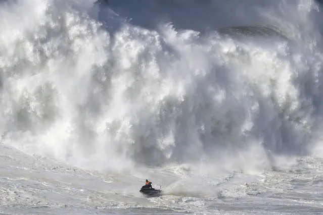 A jet ski steers away from a crashing wave during a big wave surfing session at Praia do Norte, or North Beach, in Nazare, Portugal, Friday, February 25, 2022. (Photo by Armando Franca/AP Photo)