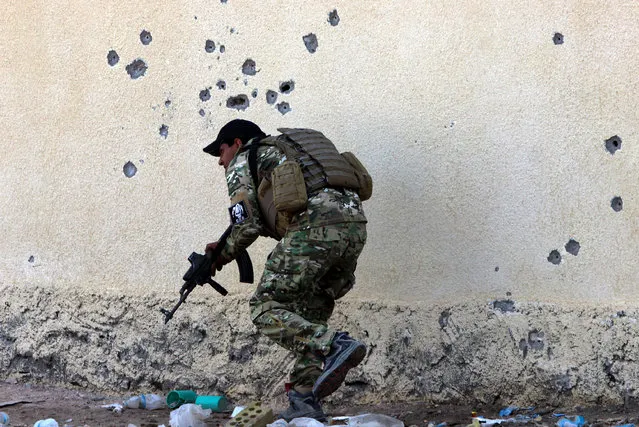 A member of the Iraqi armed forces takes up position during a military operation in the village of Sigariya, near Ramadi city, 70 km west of Baghdad, Iraq, November 15, 2015. The Iraqi armed forces, backed by militias and coalition aristrikes, continue efforts to retake the Anbar provincial capital of Ramadi, captured by the group calling themselves the Islamic State (IS) May 2015. (Photo by EPA/Stringer)