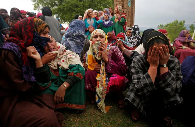 Relatives mourn as they watch the body of Umar Kumhar, a civilian who according to local media was killed during clashes with Indian security forces near the site of a gun battle, during his funeral at Pinjora village in Kashmir's Shopian district, May 3, 2018. (Photo by Danish Ismail/Reuters)