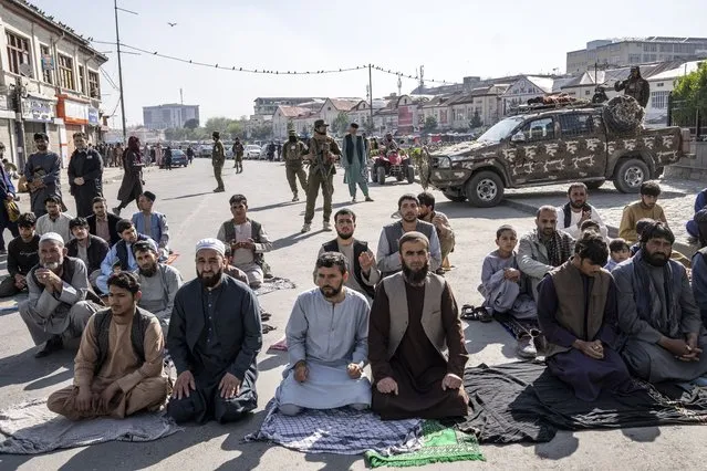 Taliban fighters stand guard as Afghan people attend Eid al-Fitr prayers, marking the end of the holy fasting month of Ramadan, in Kabul, Afghanistan, Friday, April 21, 2023. (Photo by Ebrahim Noroozi/AP Photo)
