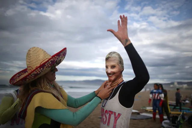 Karen Stuhr, 46, (R) wears a Nasty Woman t-shirt and a mask of U.S. Democratic presidential nominee Hillary Clinton as Rebecca Alber, 46, wears a Bad Hombre costume as they prepare to compete during the Haunted Heats Halloween Surf Contest in Santa Monica, California, U.S., October 29, 2016. (Photo by Lucy Nicholson/Reuters)